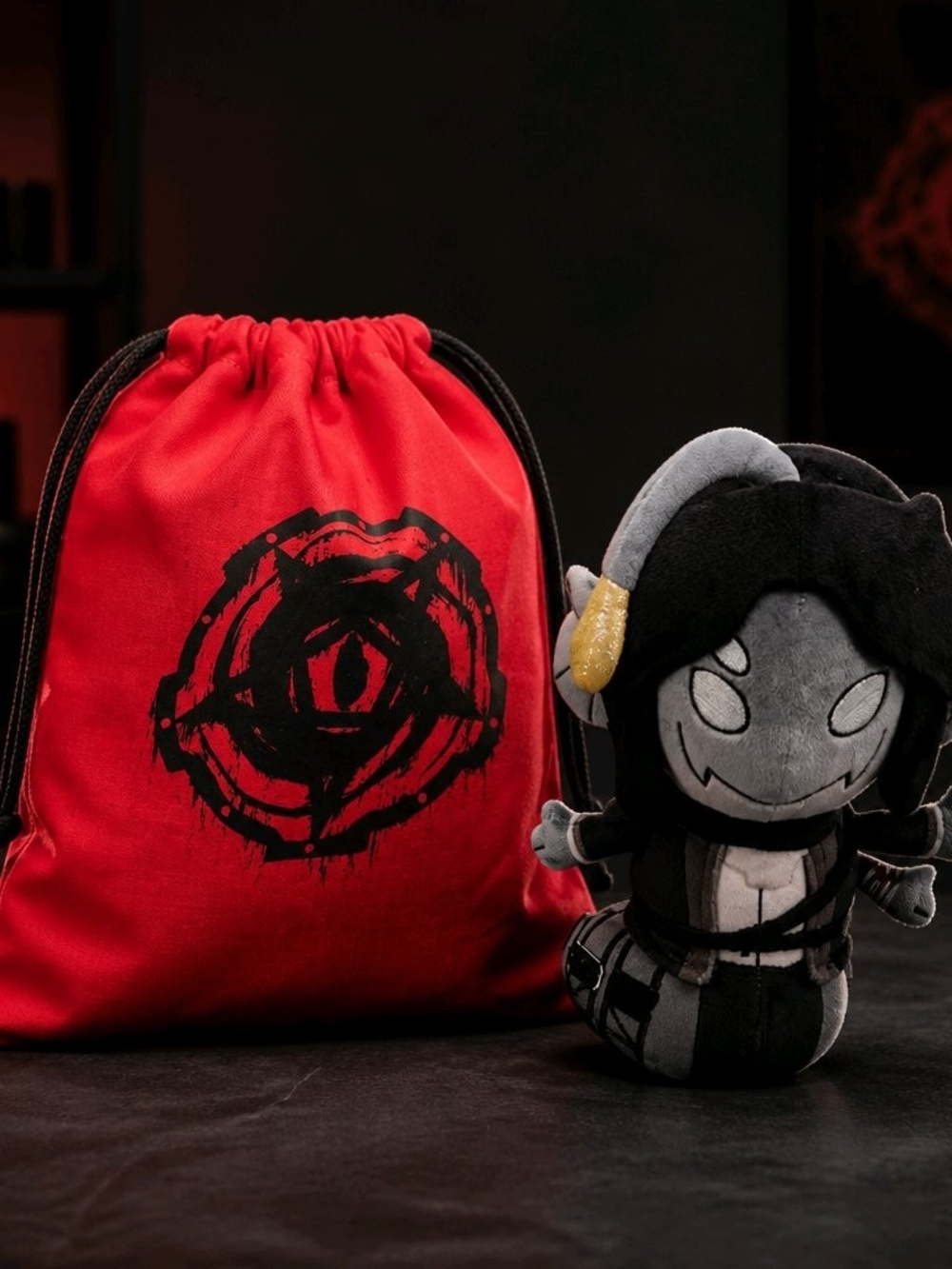 Red Drawstring Kids Toy Bag with Black Emblem and Gray Plush Figure